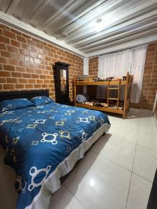 een slaapkamer met een bed en een bakstenen muur bij Finca Cimarrones Robles  +15 foto's