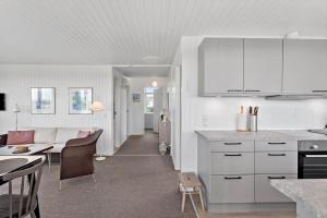 een keuken met witte kasten en een woonkamer bij 8205-Vordingborg-Strandparken-12 in Vordingborg