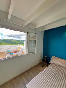 Schlafzimmer mit einem großen Fenster mit Poolblick in der Unterkunft Villa with pool and panoramic view in Rivière-Pilote