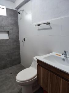 een badkamer met een wit toilet en een wastafel bij Posada el Pino 