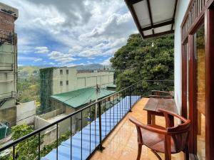 un balcon avec une table et des chaises et une piscine dans l'établissement Elegant Home Stay, à Ella