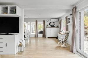 un soggiorno con mobili bianchi e TV a schermo piatto di 8214-Lundby-Timianvej-3 a Lundby