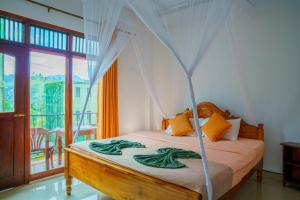 une chambre avec un lit à baldaquin et un balcon dans l'établissement Elegant Home Stay, à Ella