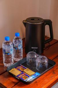 une mijoteuse et deux bouteilles d'eau sur une table dans l'établissement Elegant Home Stay, à Ella