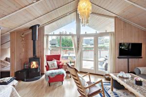 een woonkamer met een open haard, een bank en een tafel bij 3307-Stege-Maegleren-7 in Stege