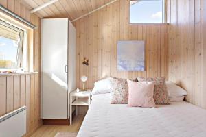 een slaapkamer met een bed in een kamer met houten wanden bij 3307-Stege-Maegleren-7 in Stege