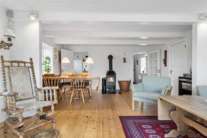 een woonkamer met een tafel en een open haard bij FA004-Faxe-Ladeplads-Brandskov-4 in Fakse Ladeplads