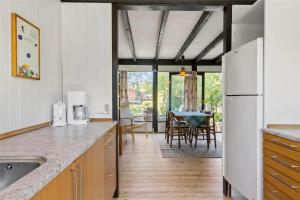 Il comprend une cuisine équipée d'un réfrigérateur et d'une table avec des chaises. dans l'établissement FA011-Faxe-Ternevej-2, à Faxe