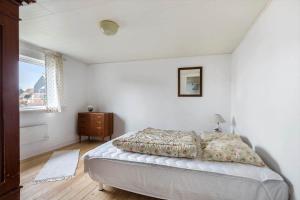 een witte slaapkamer met een bed en een raam bij 4010-Borre-Thyravej-28 in Borre