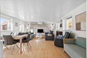 een woonkamer met een tafel, stoelen en een open haard bij S718-Stroby-Svalemosevej-18 in Strøby