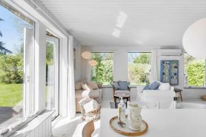 een woonkamer met witte meubels en grote ramen bij 3047-Stege-Paelen-1 in Stege +14 foto's