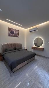 a bedroom with a large bed and a mirror at مارڤت للإيجار اليومي in Hafr Al-Batin