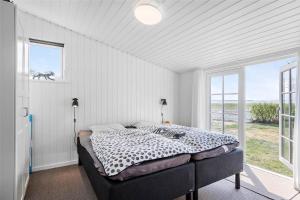 een slaapkamer met een bed en een groot raam bij 8207-Vordingborg-Strandparken-22 in Vordingborg