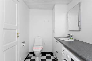 een witte badkamer met een toilet en een wastafel bij 8207-Vordingborg-Strandparken-22 in Vordingborg +10 foto's