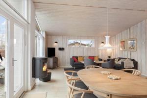 een woonkamer met een tafel en een open haard bij 3044-Stege-Paelen-24 in Stege