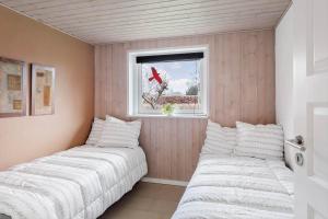 twee bedden in een kleine kamer met een raam bij 3044-Stege-Paelen-24 in Stege