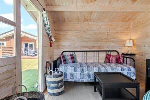una camera da letto con un letto in una cabina di legno di FA035-Faxe-Ladeplads-Strandlodden-9 a Fakse Ladeplads