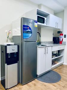 a stainless steel refrigerator in a kitchen with white cabinets at Amani Grand Resort Residences Pool Netflix Gym near Airport in Lapu Lapu City