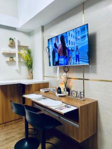 a room with a desk with a tv on the wall at Amani Grand Resort Residences Pool Netflix Gym near Airport in Lapu Lapu City