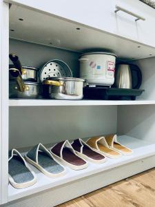 a row of shoes on a shelf in a kitchen at Amani Grand Resort Residences Pool Netflix Gym near Airport in Lapu Lapu City +8 photos