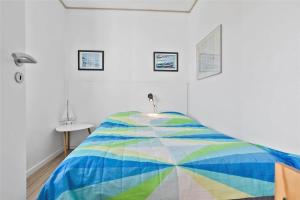 ein Schlafzimmer mit einer bunten Bettdecke auf einem Bett in der Unterkunft 4106 Borre - Klintholm Havneby 6 in Borre
