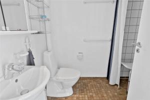 ein weißes Badezimmer mit Toilette und Waschbecken in der Unterkunft 4106 Borre - Klintholm Havneby 6 in Borre + 20 Fotos