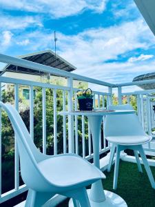 a balcony with two chairs and a table at Amani Grand Resort Residences Pool Netflix Gym near Airport in Lapu Lapu City