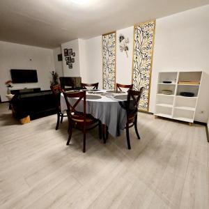 - une salle à manger avec une table, des chaises et un piano dans l'établissement Appartements Miawé, à Tarbes