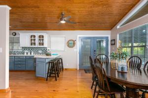 een keuken met blauwe kasten en een tafel en stoelen bij Riverfront Getaway On Guadalupe River in New Braunfels +8 foto's