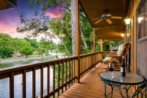 een veranda met een tafel en uitzicht op het water bij Riverfront Getaway On Guadalupe River in New Braunfels