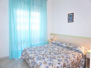 a bedroom with a bed and a blue curtain at Caorle Holiday Home with Terrace in Porto Santa Margherita di Caorle