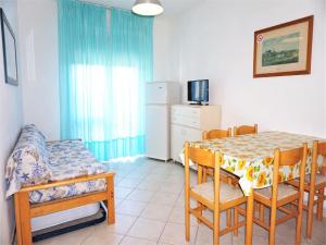 a dining room with a table and chairs and a kitchen at Caorle Holiday Home with Terrace in Porto Santa Margherita di Caorle