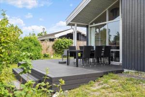 a deck with black chairs and a table on a house at 1060-Stege-Ulvshalevej-213 in Stege