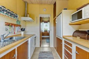 een kleine keuken met een spoelbak en een magnetron bij 3053-Stege-Tjaeregryden-25 in Stege