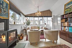 een woonkamer met een open haard en een tafel en stoelen bij S701-Stroby-Kystvejen-164 in Strøby