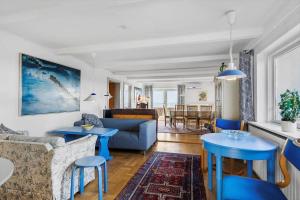 een woonkamer met blauwe tafels en een bank bij 8211-Mern-Havnen-4 in Mern
