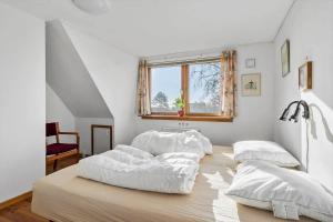 een slaapkamer met drie bedden op een houten vloer bij 8211-Mern-Havnen-4 in Mern