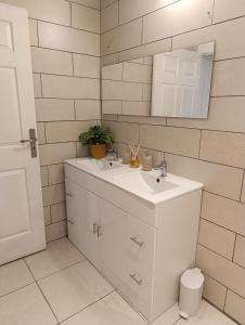 een witte badkamer met een wastafel en een spiegel bij Du Pure Cocooning in Saint-Philippe +12 foto's