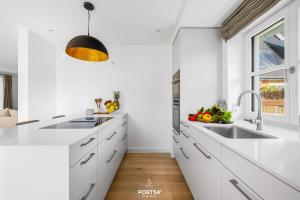 een witte keuken met een wastafel en een raam bij Villa Tinnum Sylt in Tinnum