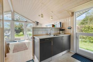 a kitchen with a sink and a large window at R956-Rodvig-Laerkevej-8 in Rødvig