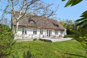 een wit huis met een veranda en een tuin bij 3302-Stege-Brakildevej-2 in Stege