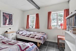 een slaapkamer met 2 bedden, een bureau en 2 ramen bij 6318-Stege-Holtegardsvej-18-B in Stege