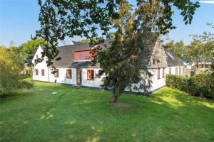 een groot wit huis met een boom in de tuin bij 6318-Stege-Holtegardsvej-18-B in Stege