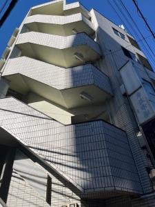 een hoog gebouw met trappen aan de zijkant bij Shinehouse2 in Kawaguchi