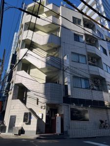 ein hohes Gebäude mit einer Treppe davor in der Unterkunft Shinehouse2 in Kawaguchi