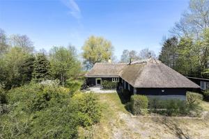 een oud huis met een rieten dak in een veld bij S760-Stroby-Ladeplads-Spaettevej-14 in Strøby Ladeplads