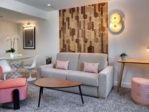 un soggiorno con un divano e un tavolo di Pullman La Pléiade Montpellier Centre a Montpellier