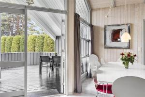 een eetkamer met een witte tafel en een balkon bij 3313-Stege-Overlid-11 in Stege +16 foto's
