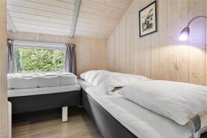 een slaapkamer met twee bedden en een raam bij 3313-Stege-Overlid-11 in Stege
