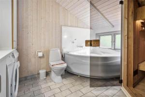 een badkamer met een bad, een toilet en een wastafel bij 3313-Stege-Overlid-11 in Stege